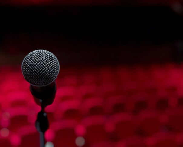 Microfoon op een rood verlicht podium voor een komische voorstelling