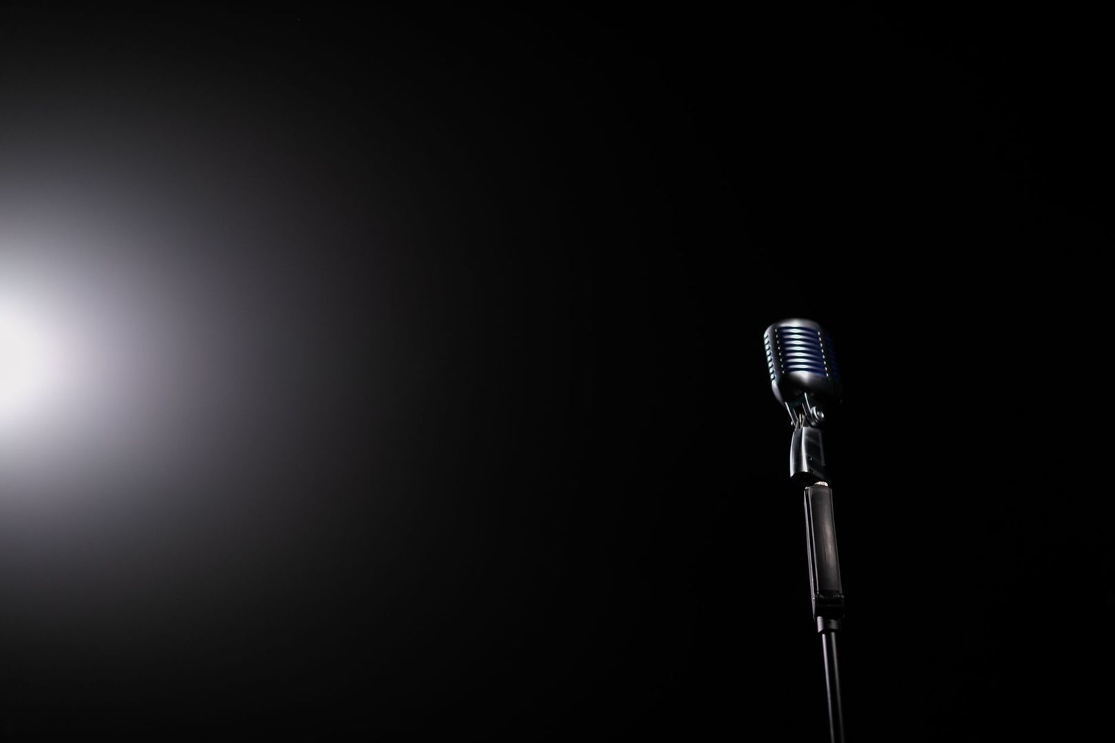 Vintage microfoon op een donker podium, klaar voor scherpe politieke satire